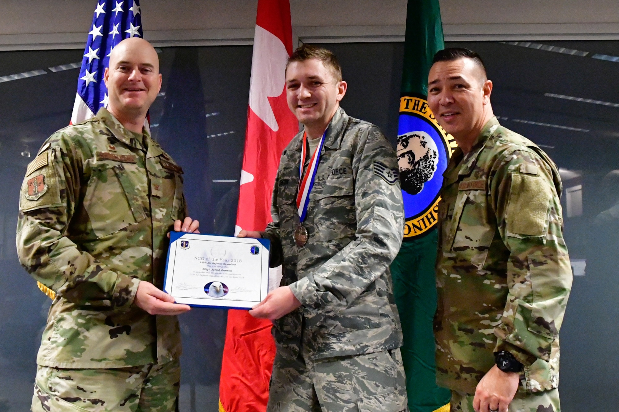 Staff Sgt. Jared Denton, 225th Air Defense Squadron NCOIC of surveillance training is named the 225th ADS NCO of the Year Dec. 1, 2018 on Joint Base Lewis-McChord.  Denton poses with Col. Brett Bosselmann (left), 225th ADS commander and Chief Master Sgt. Allan Lawson, 225th ADS chief enlisted manager. (U.S. Air National Guard photo by Maj. Kimberly D. Burke)