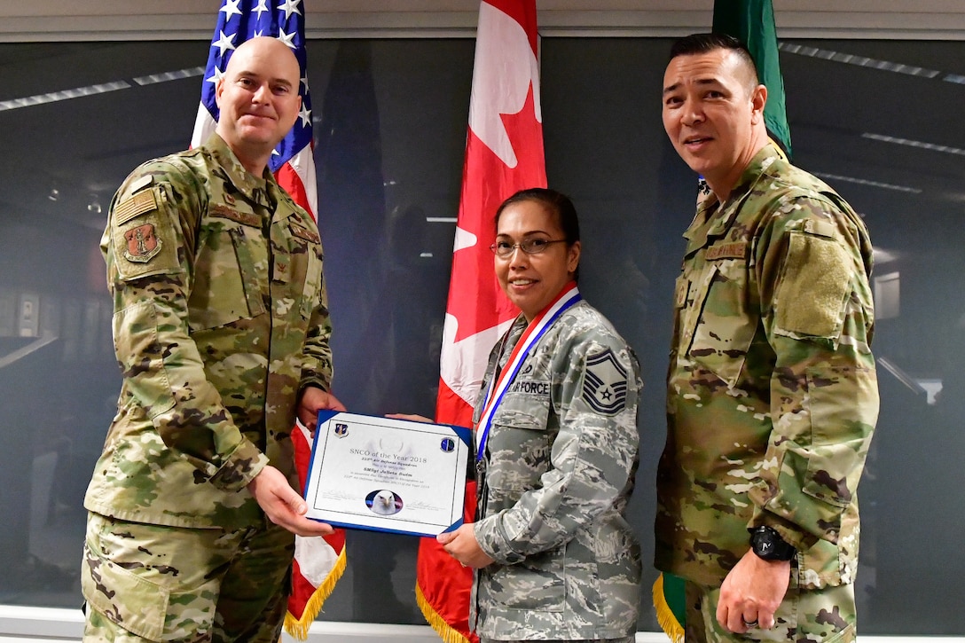 Senior Master Sgt. Julietta Swin, 225th Air Defense Squadron superintendent of data link operations is named the 225th ADS NCO of the Year Dec. 1, 2018 on Joint Base Lewis-McChord.  Swim poses with Col. Brett Bosselmann (left), 225th ADS commander and Chief Master Sgt. Allan Lawson, 225th ADS chief enlisted manager. (U.S. Air National Guard photo by Maj. Kimberly D. Burke)