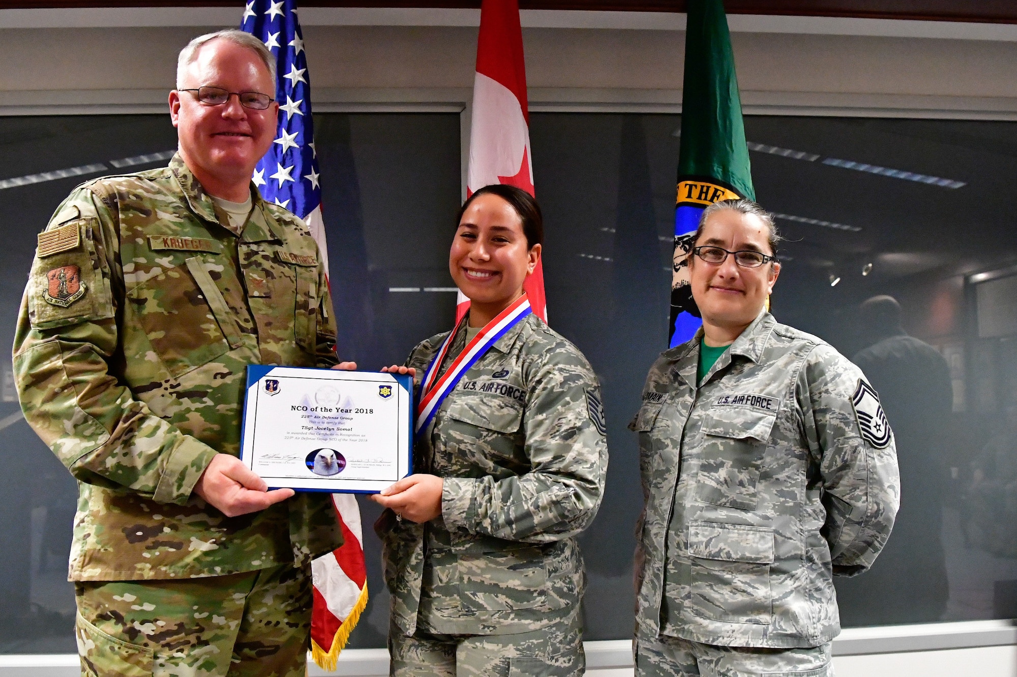 Tech. Sgt. Jocelyn Somol, 225th Air Defense Group human resource specialist is named the 225th ADG NCO of the Year Dec. 1, 2018 on Joint Base Lewis-McChord.  Somol poses with Col. William Krueger (left), 225th ADG commander and Senior Master Sgt. Rebekah St. Romain, 225th ADG superintendent.  (U.S. Air National Guard photo by Maj. Kimberly D. Burke)