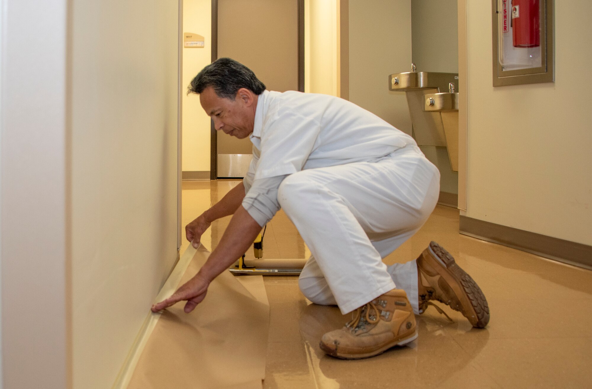 Felix Guevara touches up a wall, Nov. 20, 2018, David Grant U.S. Air Force Medical Center, Travis Air Force Base, California. Guevara has spent the last 30 years walking DGMC repairing and painting walls as well as all the directional signs. Guevara was the first maintenance contractor hired at DGMC in 1988.  He witnessed the building of DGMC from the ground up. (U.S. Air Force Photo by Heide Couch)