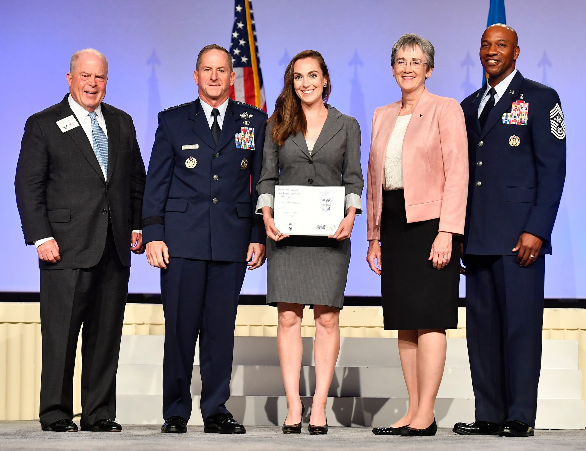 Morgan Noller, center, receives the Joan Orr Spouse of the Year Award from Secretary of the Air Force Heather Wilson, second from right, Air Force Chief of Staff Gen. David L. Goldfein, second from left, Chief Master Sgt. of the Air Force Kaleth Wright, far right, and Whit Peters, Chairman of the Air Force Association Board during the AFA Air, Space and Cyber Conference in National Harbor, Maryland, Sept. 17, 2018. Noller is the spouse of Capt. Steven Noller, 21st Airlift Squadron, Travis Air Force Base, California. (U.S. Air Force photo by Staff Sgt. Rusty Frank)