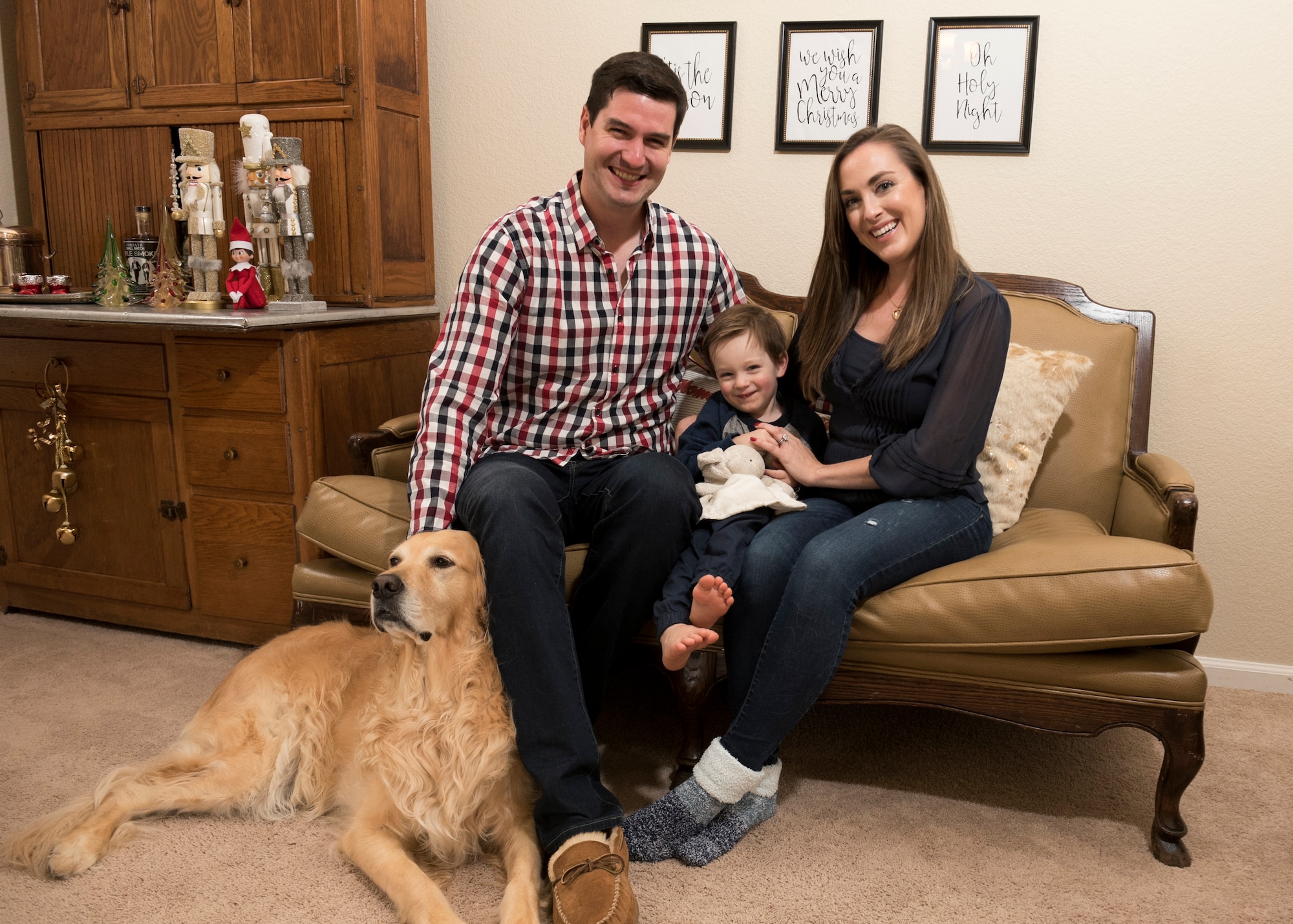 Capt. Steven Noller, 21st Airlift Squadron pilot, his spouse Morgan and their son Camden, pose for a family portrait in their home in Vacaville, California, Dec. 5, 2018. Morgan won the 2018 Joan Orr Air Force Spouse of the Year Award. (U.S. Air Force photo by Lan Kim)