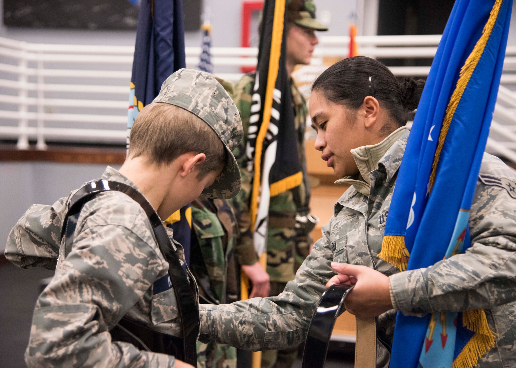 Christian Maple, Civil Air Patrol Spokane Composite Squadron cadet, receives assistance from Airman 1st Class Larrah Lara, 92nd Air Refueling Wing Honor Guardsmen, while practicing "presenting colors" at Fairchild Air Force Base, Washington, Nov. 26, 2018. Fairchild Honor Guard teams are composed of Airmen from different career fields, bringing a diversity of age and experience. (U.S. Air Force photo/ Senior Airman Ryan Lackey)