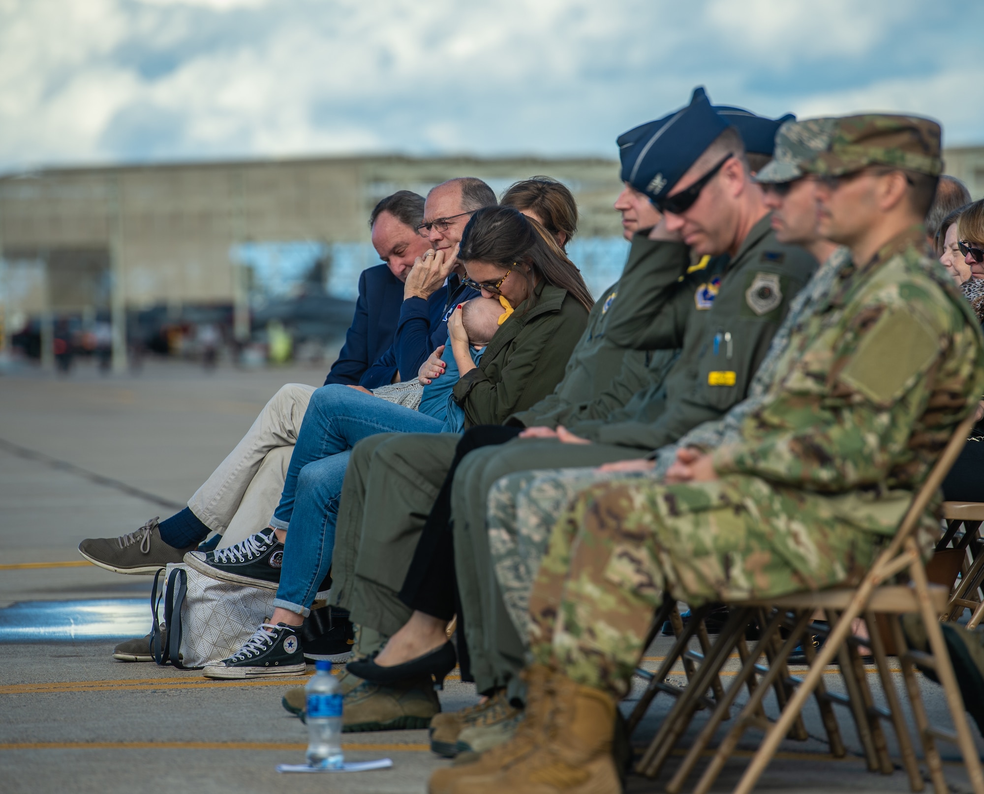 Kelsey Grace, spouse of Capt. Stephen “Trip” Grace, kisses their daughter, Georgia Grace, during Capt. Grace’s memorial service Dec. 7, 2018, at Luke Air Force Base, Ariz. Numerous family members and friends were in attendance to honor and celebrate the life of Capt. Grace. (U.S. Air Force photo by Senior Airman Alexander Cook)