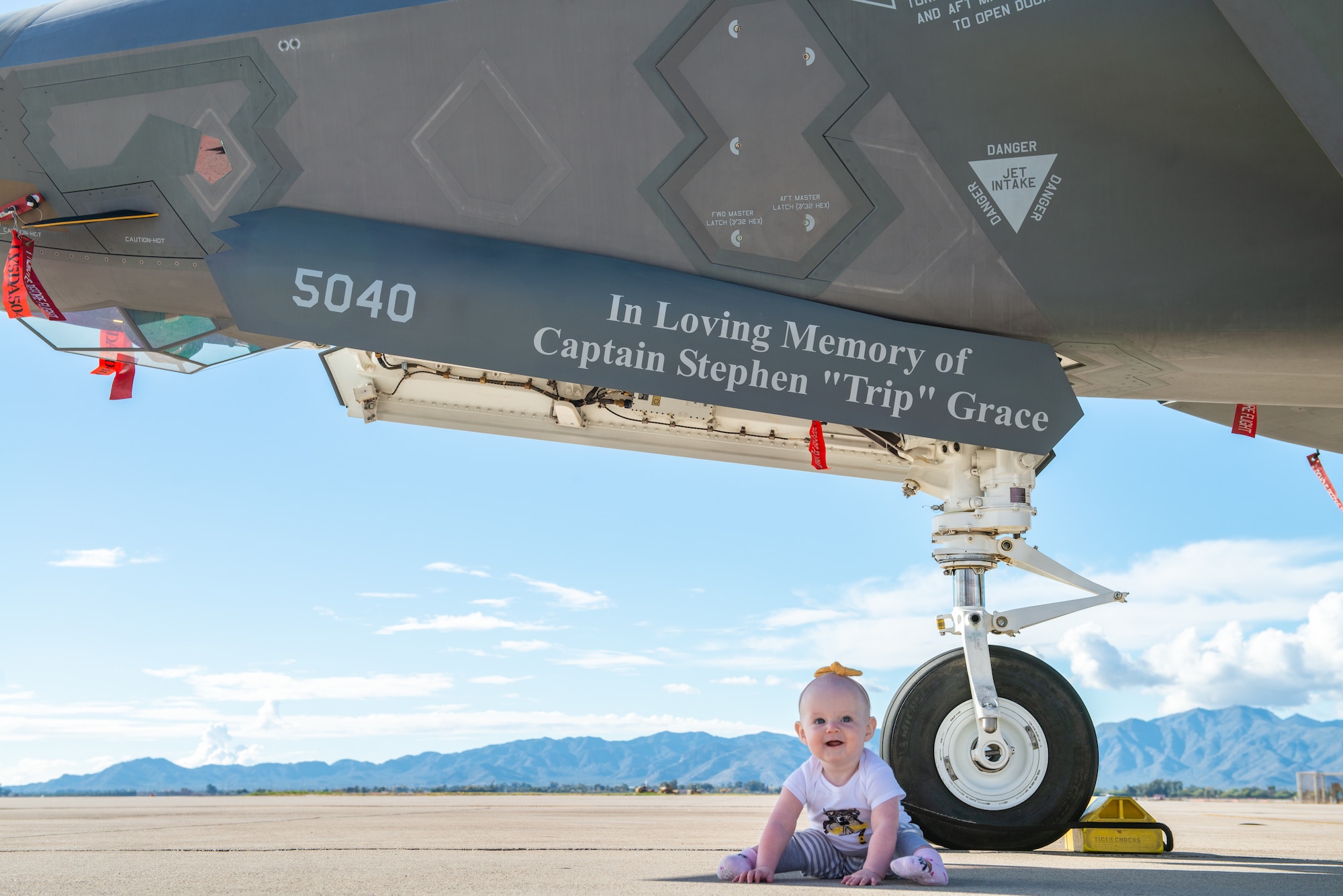 Georgia Grace, daughter of Capt. Stephen “Trip” Grace, sits in front of an F-35A Lightning II dedicated in her father’s name Dec. 7, 2018, at Luke Air Force Base, Ariz. Capt. Capt. Grace was an instructor pilot in the 61st Fighter Squadron and was twice recognized as Company Grade Officer of the Quarter. (U.S. Air Force photo by Senior Airman Alexander Cook)