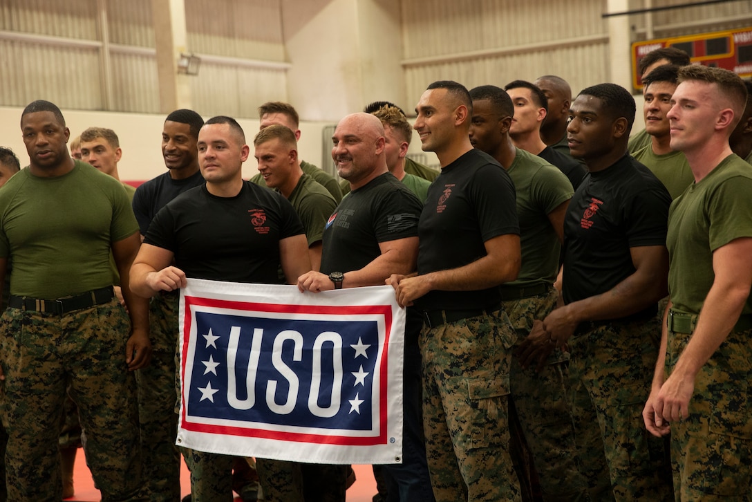 Martial Arts Instructor Jay Glazer and U.S. Marines attending the Special Mixed Martial Arts (MMA) Clinic held aboard Marine Corps Base Hawaii take a group photo, Dec. 11, 2018. MMA figure heads hosted by the United Service Organization spoke about and demonstrated their competative combat sport experience to Marines aboard the base, relating the skill set to the Marine Corps Martial Arts Program and the everpresent Marine Corps combat mindset. (U.S. Marine Corps Photo by Sgt. Alex Kouns)