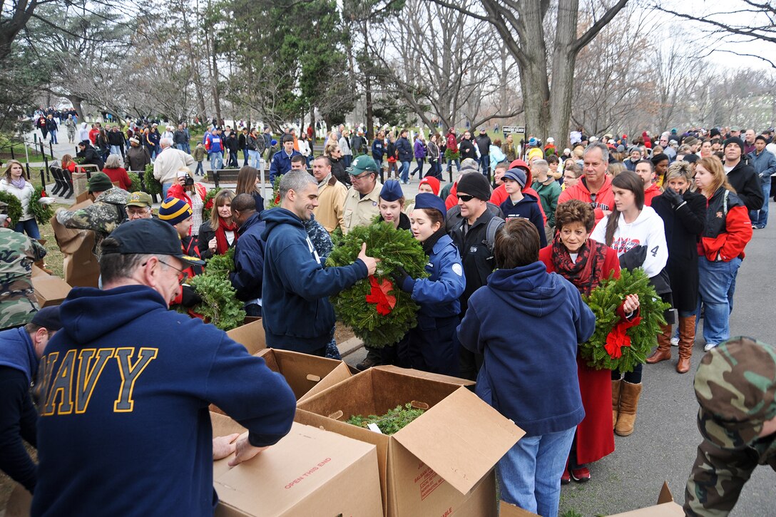 Navy sailors distribute wreaths to volunteers.
