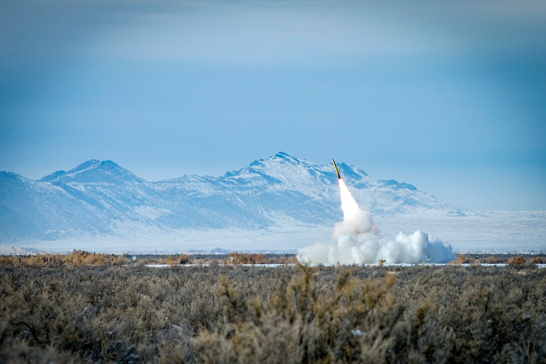 A rocket launches in the middle of a large field.