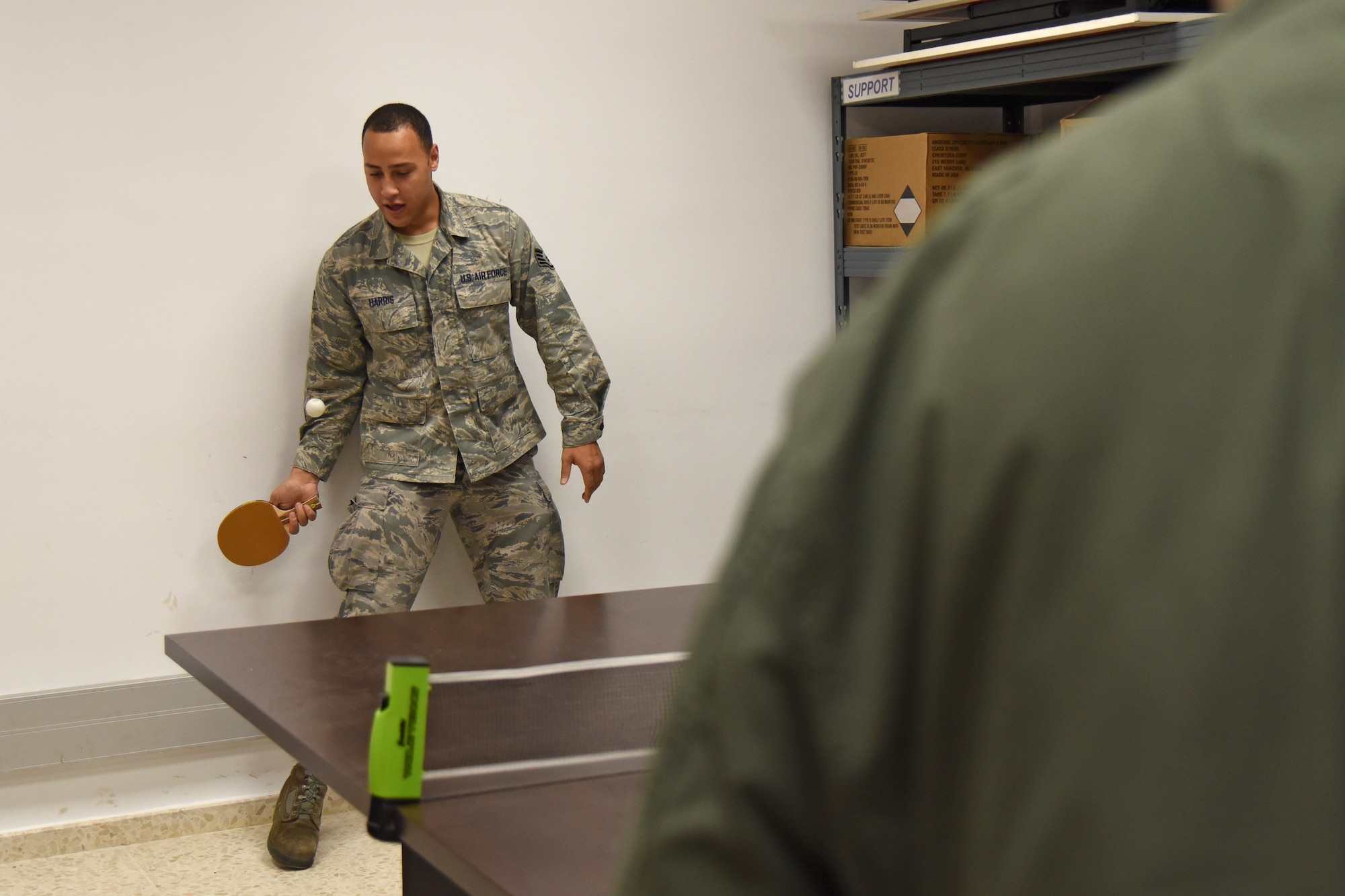 Staff Sgt. Edward Harris, 92nd Aircraft Maintenance Squadron crew chief, plays table tennis with Col. Derek Salmi, 92nd Air Refueling Wing commander, during a site visit Dec. 4, 2018, at Morón Air Base, Spain. During the month of December, more than 40 holiday care packages made their way to Team Fairchild Airmen stationed at Morón AB as part of KREM 2 News’ initiative, Treats 2 Troops. (U.S. Air Force photo/Staff Sgt. Mackenzie Mendez)