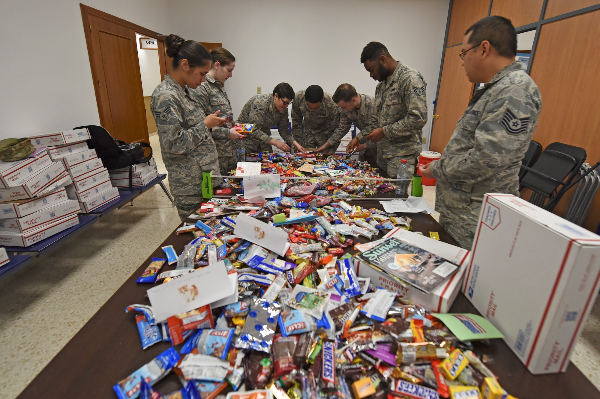 Team Fairchild Airmen stationed abroad open a Treats 2 Troops package Dec. 4, 2018, at Morón Air Base, Spain. Treats 2 Troops is part of KREM 2 News' initiative to spread holiday cheer to military service members stationed abroad during the holiday season. (U.S. Air Force photo/Staff Sgt. Mackenzie Mendez)