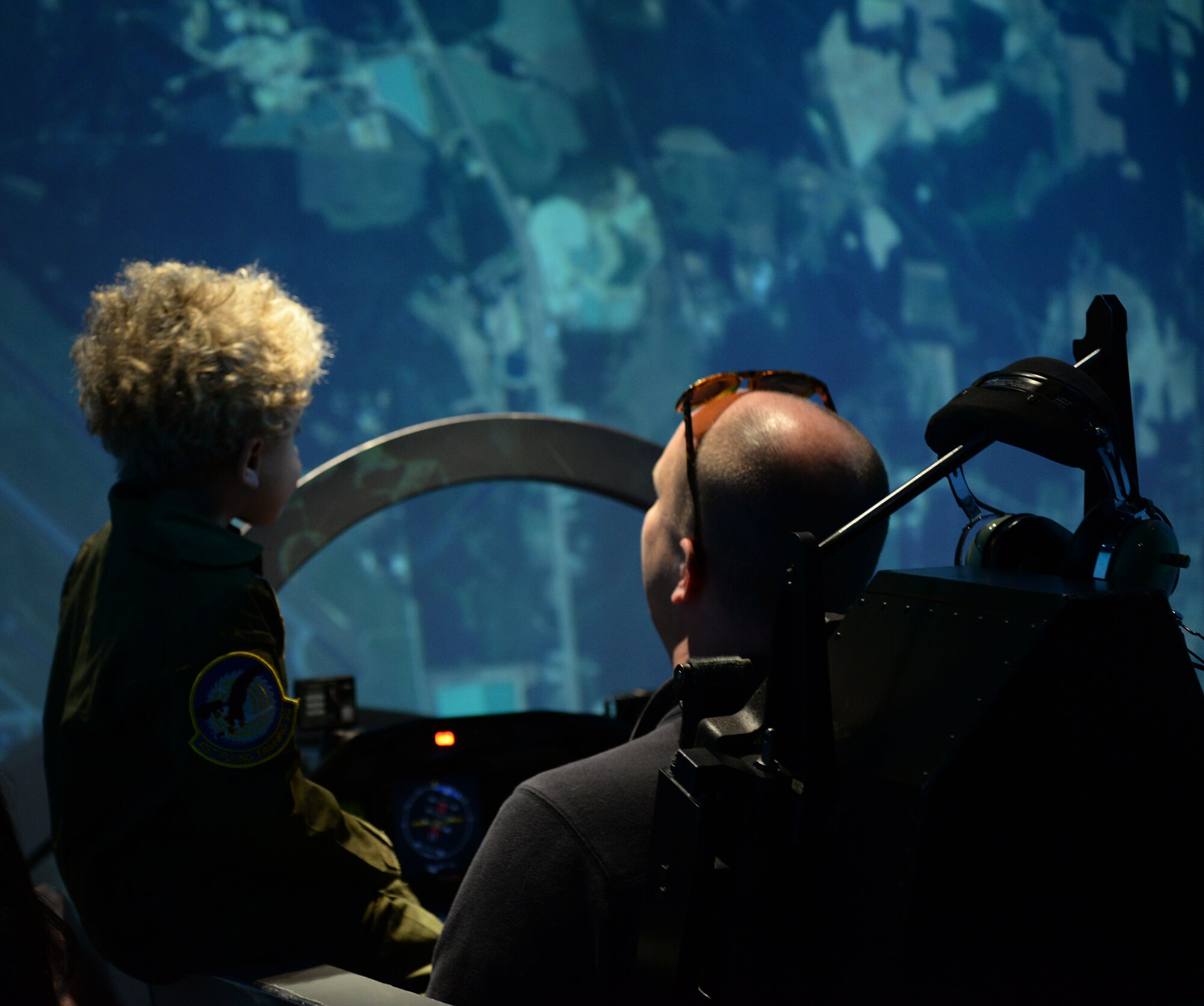 Tobias Taylor, Pilot for a Day, and Clay Taylor, Tobias’ father, try out a T-6 simulator at the 14th Operations Group, Dec. 6, 2018, on Columbus Air Force Base, Mississippi. Pilot for a Day is a program where medically disabled youth get a “red carpet day” custom-tailored to their desires and capabilities. (U.S. Air Force photo by Airman Hannah Bean)