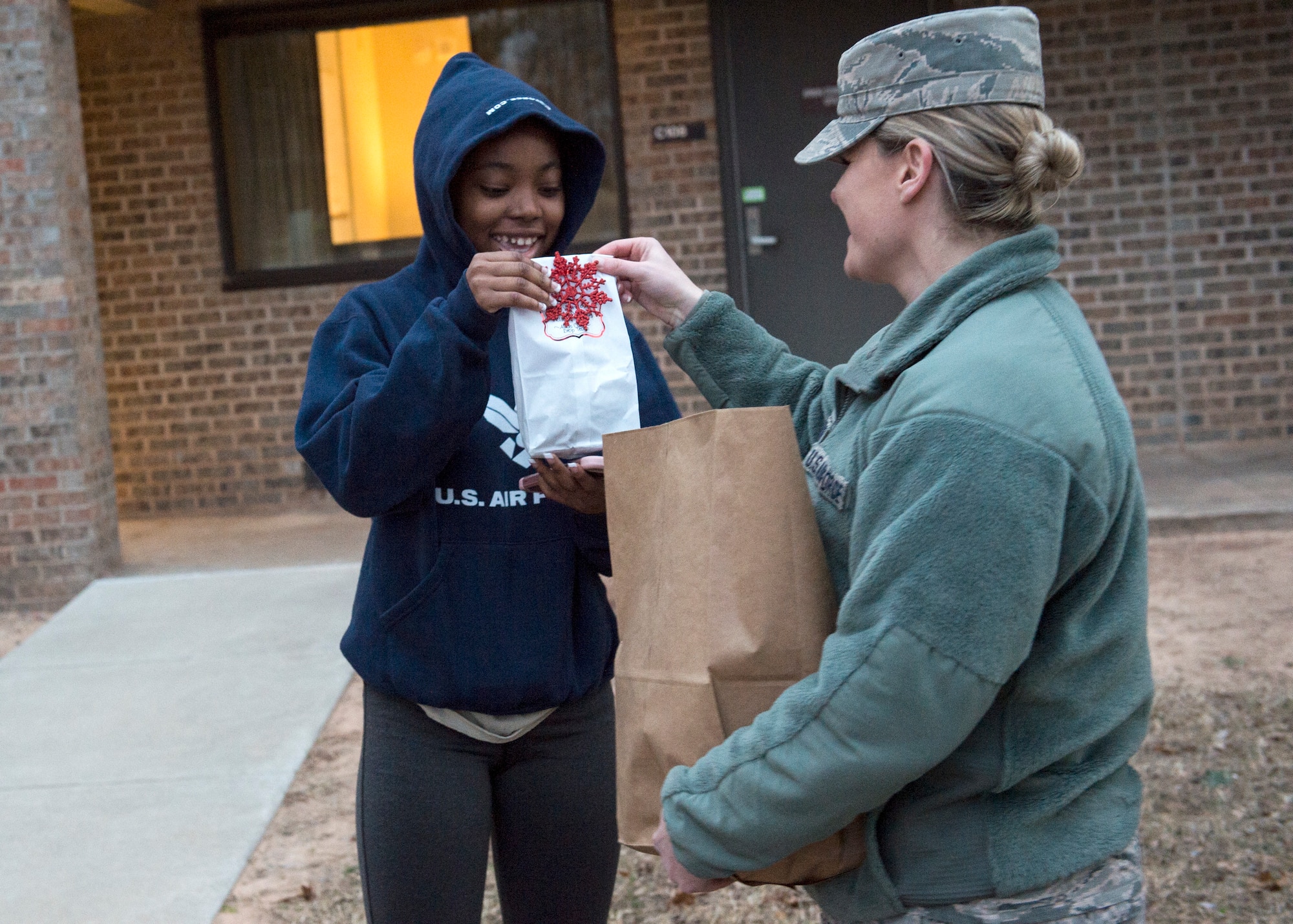 U.S. Air Force Maj. Johanna O’Toole, 97th Logistics Readiness Squadron commander, hands cookies to U.S. Air Force Airman Monique Bolton, 97th LRS vehicle maintenance journeyman, Dec. 11, 2018, at Altus Air Force Base, Okla.