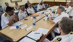 U.S. Navy stock photo of members from the Indian Navy and U.S. 7th Fleet discussing engagements between the two nations throughout the year.