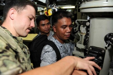 PUERTO PRINCESA, Philippines (Dec. 10, 2018) – Lt. j.g. Aaron Sims, assigned to the Los Angeles-class attack submarine USS Greeneville (SSN 772), shows members of the Philippine Navy how to operate a periscope during a tour of the submarine, Dec. 10. Land is in the Philippines on a scheduled port visit to provide maintenance, hotel services, and logistical support to submarines and surface ships in the 5th and 7th Fleet areas of responsibility. Land's visit promotes ongoing theater security cooperation efforts furthering the longstanding partnership between the United States and Philippine navies. (U.S. Navy photo by Mass Communication Specialist 2nd Class Jordyn Diomede/Released)
