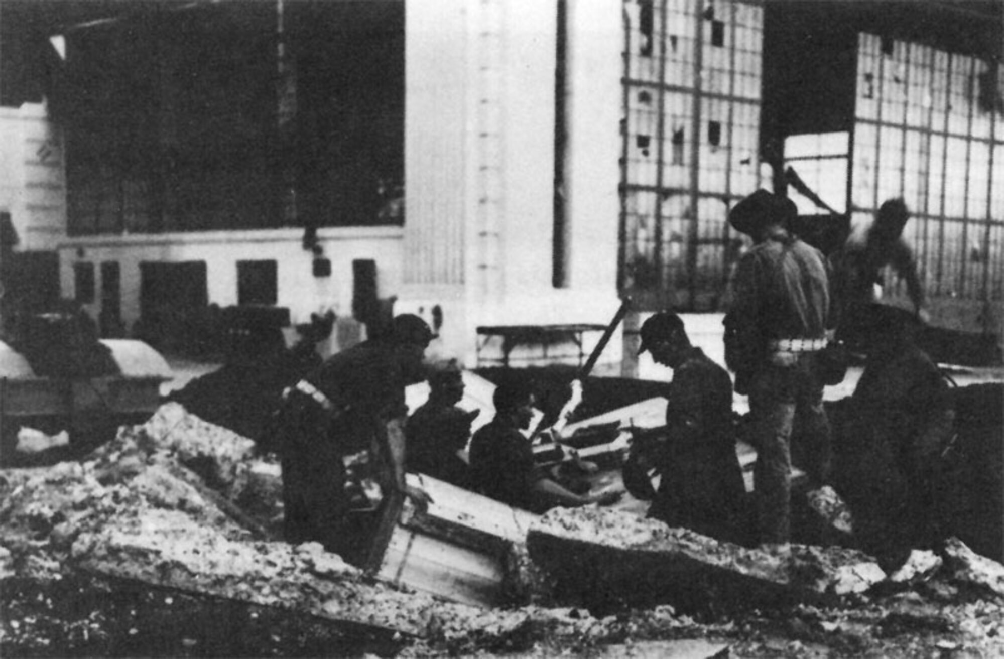 Airmen with other personnel man a gun emplacement set up in a bomb crater between Hangars 11-13 and 15-17, Hickam Field, Dec. 7, 1941. (Courtesy photo)