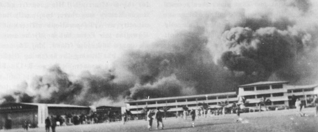 The first bombs to strike Hickam Field Dec. 7, 1941 were dropped on Hawaiian Air Depot buildings and the hangar line, causing thick clouds of smoke to billow upward. (Courtesy photo, John W. Wilson)