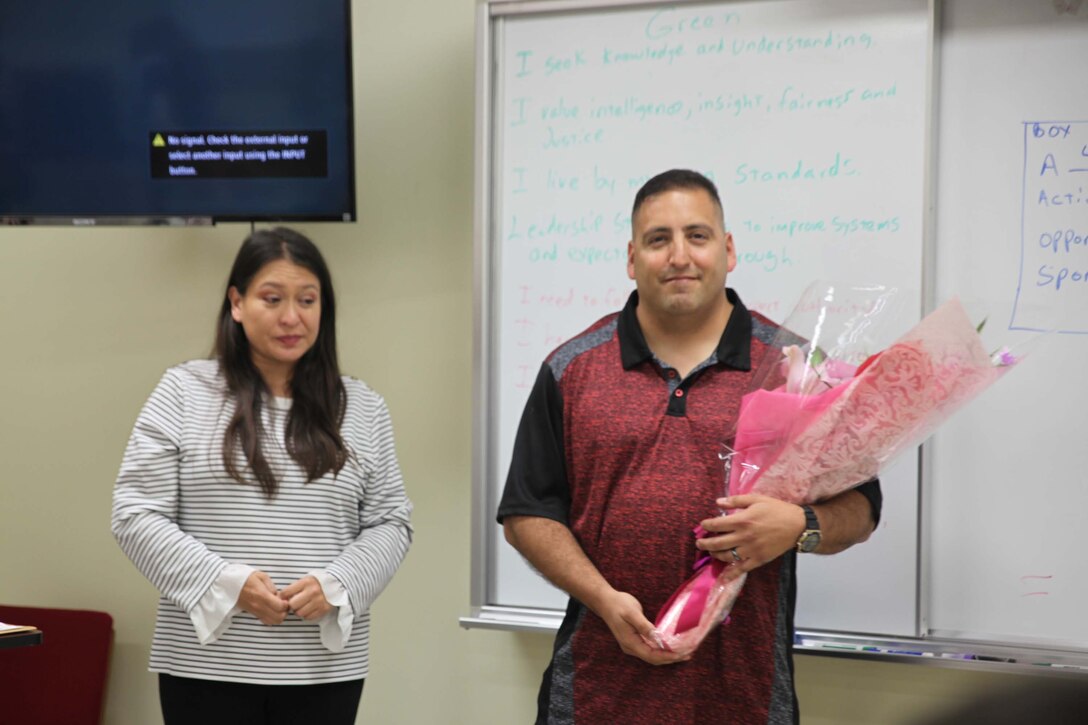 Local residents in the English class at Camp Schwab show gratitude for Master Sgt. Anthony Camina and his wife, Michelle's contribution, and present couple with a bouquet and a cake.