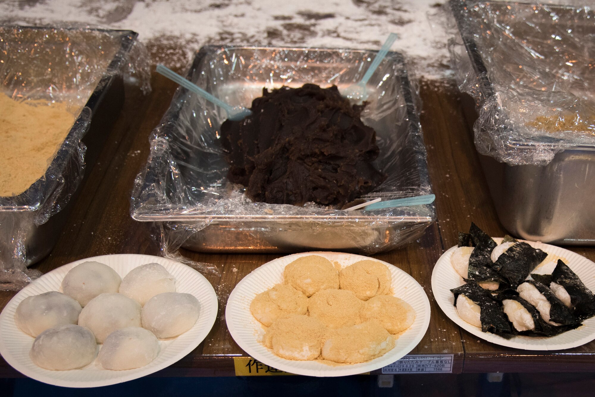 (Left to Right) Mochi with filled with anko, mochi coated with sweet roasted soybean flour and mochi coated with soy sauce and wrapped with nori seaweed sit on a table during a rice pounding event hosted by Japan Air Self-Defense Force at Yokota Air Base, Japan, Dec. 12, 2018.