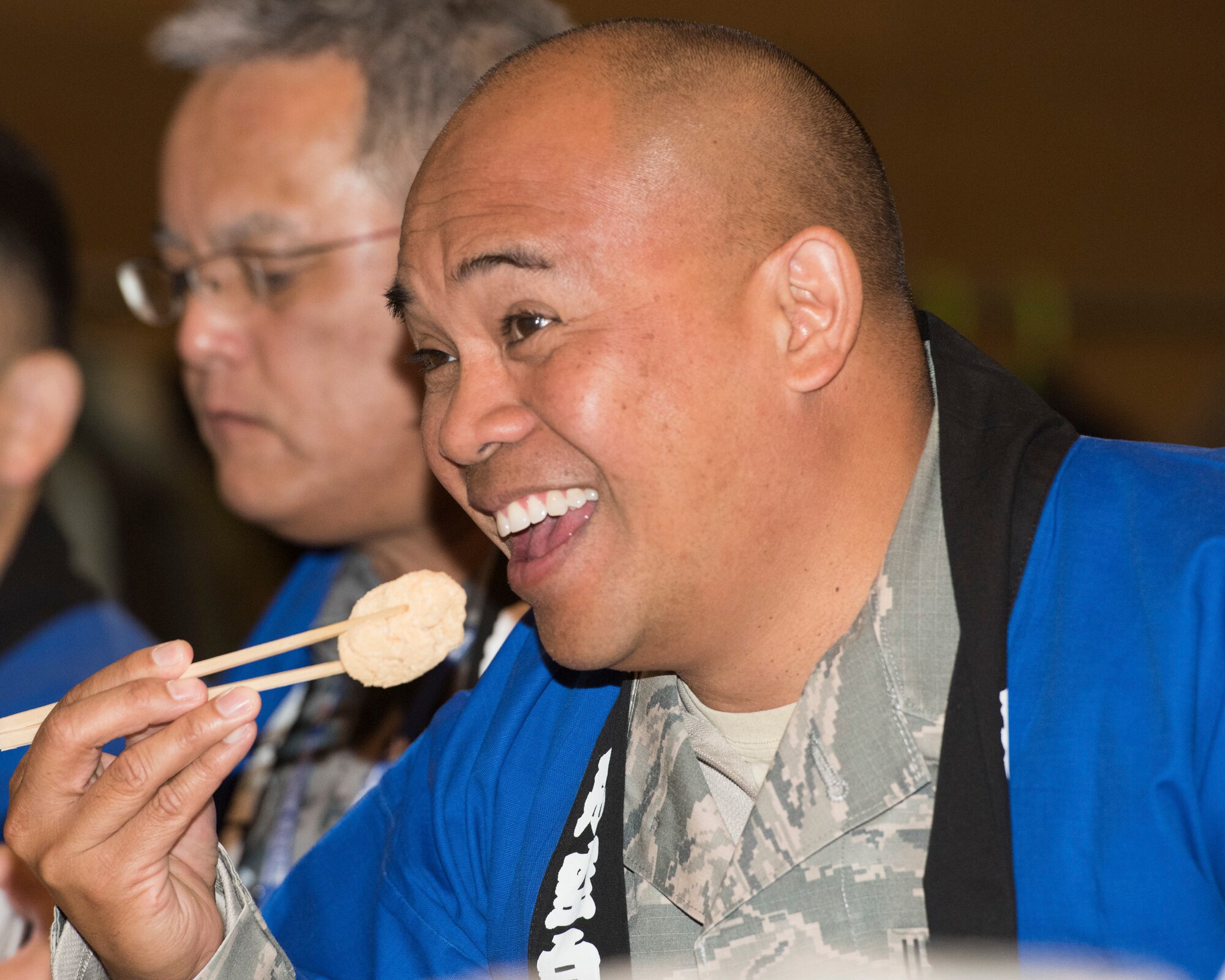 Chief Master Sgt. Brandon Guzman, 374th Maintenance Group superintendent, eats a rice cake coated with sweet roasted soybean flour during a rice pounding event hosted by Japan Air Self- Defense Force at Yokota Air Base, Japan, Dec. 12, 2018.
