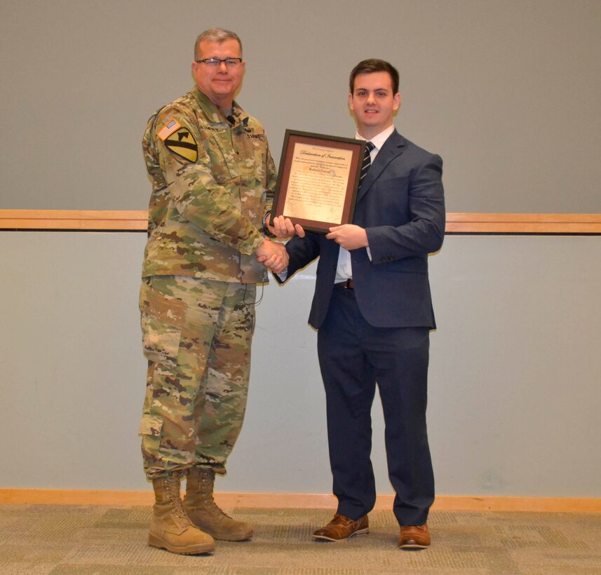 Defense Logistics Agency Troop Support commander Army Brig. Gen. Mark Simerly presents the DLA Troop Support Declaration of Innovation to Rob Fagan during a Town Hall in Philadelphia, Nov.11, 2018. Fagan, a junior contract specialist on the heraldic team in DLA Troop Support’s Clothing and Textile supply chain, was instrumental in standardizing and developing a new material to be used in flags for the military. (Photo by Alexandria Brimage-Gray/DLA Troop Support)