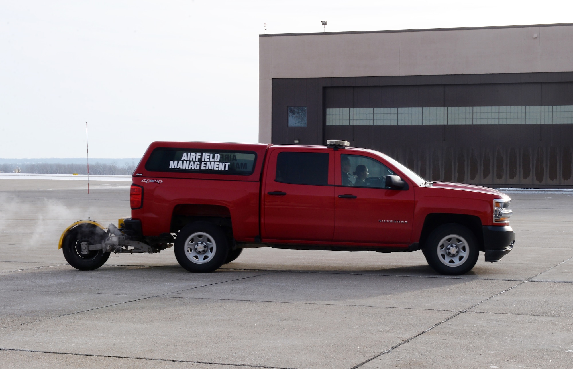 U.S. Air Force Staff Sgt. Kathryn Infantino, 55th Operations Support Squadron airfield management, drives an airfield management vehicle with the new RT3 friction tester on the back on Offutt Air Force Base, Nebraska, Dec. 11, 2018. The RT3, when activated, takes continuous friction readings. (U.S. Air Force photo by Charles J. Haymond)