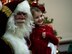 Santa and a young member of Team Scott sit for a photo during the Holiday Party and Tree Lighting Ceremony, Dec. 7, 2018, at Scott Air Force Base, Illinois. During the event, the non-profit organization Trees for Troops provided free Christmas trees to families around base, ensuring all young Airmen and families of deployed service members were able to decorate for the holidays.