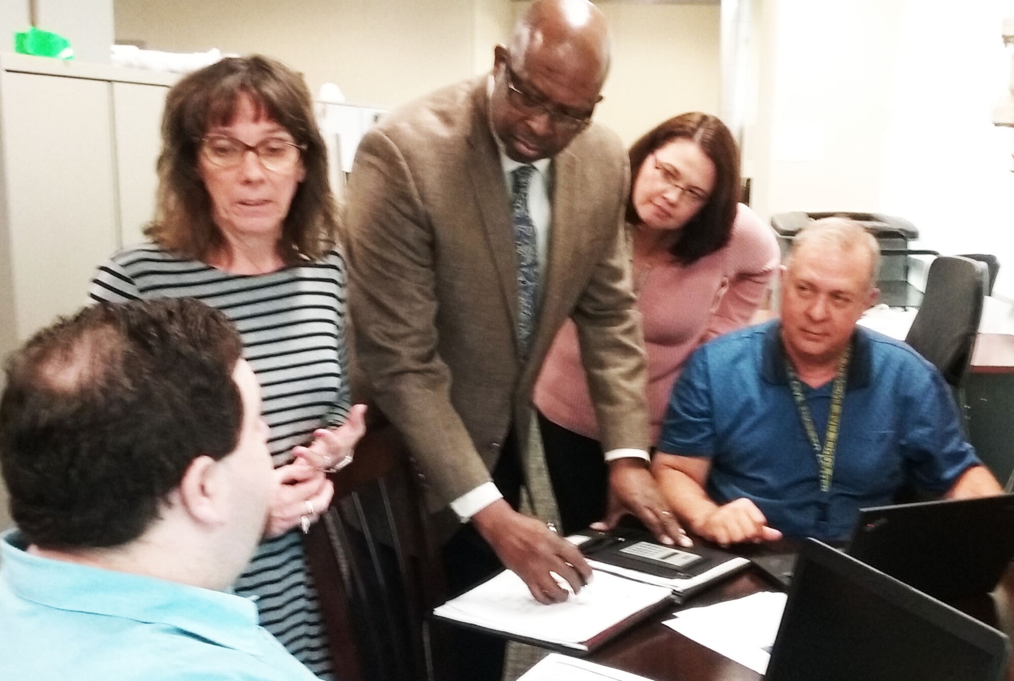 Members of AFIMSC's Financial Operations Division discuss a plan for certifying the time cards of nearly 700 Tyndall Air Force Base employees affected by Hurricane Michael. From left to right, Jason Schneider, Linda Alcala, Charles Hendricks, Ellen Lounsberry, and Rick Baltes. (U.S. Air Force Photo by Ed Shannon)
