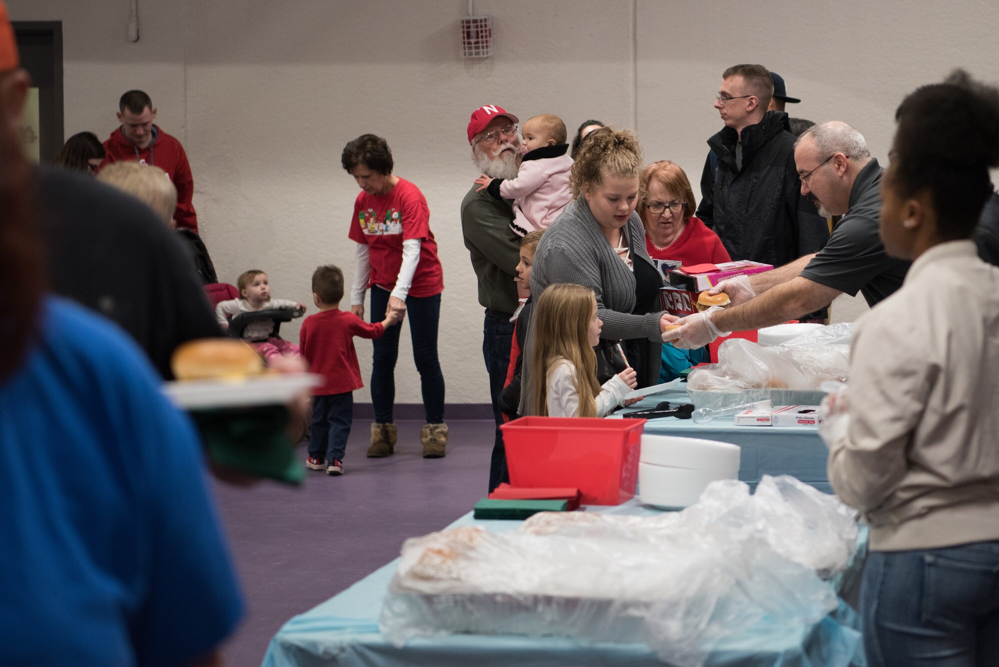 Attendees of the 25th Annual Winter Wonderland go through the food line Dec. 7, 2018, at the Lied Activity Center in Bellevue, Nebraska. The event featured food, crafts, games, clowns, face painting, toys and family photos with Mr. and Mrs. Claus. (U.S. Air Force photo by Senior Airman Jacob Skovo)