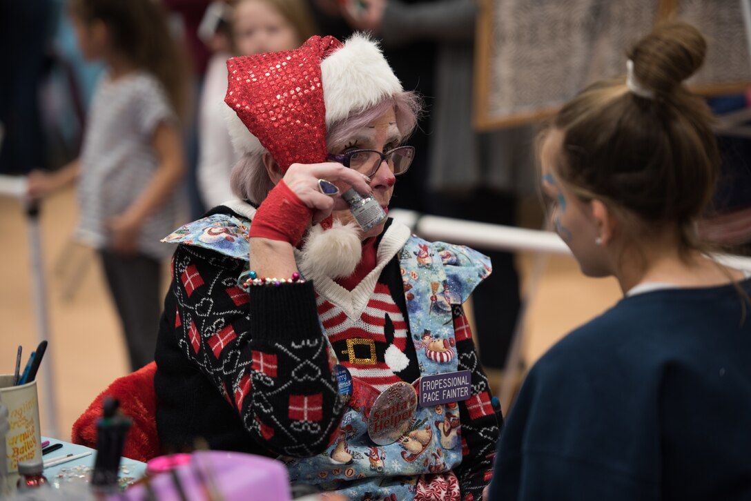 A volunteer at the 25th Annual Winter Wonderland event paints a child’s face Dec. 7, 2018, at the Lied Activity Center in Bellevue, Nebraska. The family focused event was organized, led and ran by the Offutt Enlisted Spouses Club and volunteers. (U.S. Air Force photo by Senior Airman Jacob Skovo)