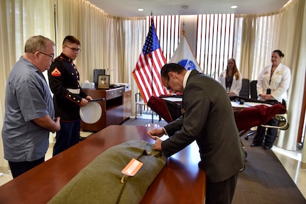 U.S. Marine Corps Lance Cpl. Kenneth Henson and personnel from the Defense POW/MIA Accounting Agency (DPAA) watch as a local mortician secures the remains of U.S. Army Cpl. Albert Mills during a chain of custody event at the DPAA facility at Joint Base Pearl Harbor-Hickam, Hawaii, Nov. 9, 2018. Henson, Mills' great nephew-in-law, will served as special escort of the remains during transport to Mills’ hometown of Dallas. DPAA conducts global search, recovery and laboratory operations to provide the fullest possible accounting for our missing personnel to their families and the nation. (U.S. Air Force photo by Tech. Sgt. Kathrine Dodd)