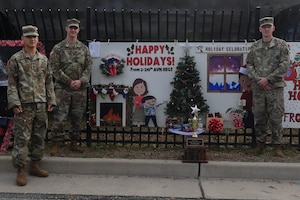 U.S Army Soldiers assigned to the 210th Aviation Regiment, 2nd Battalion, 128th Avn. Brigade stand in front of their winning holiday card at Joint Base Langley-Eustis, Virginia, Dec. 13, 2018. The winning units received gift cards that can be used towards morale events. (U.S. Air Force photo by Senior Airman Derek Seifert)