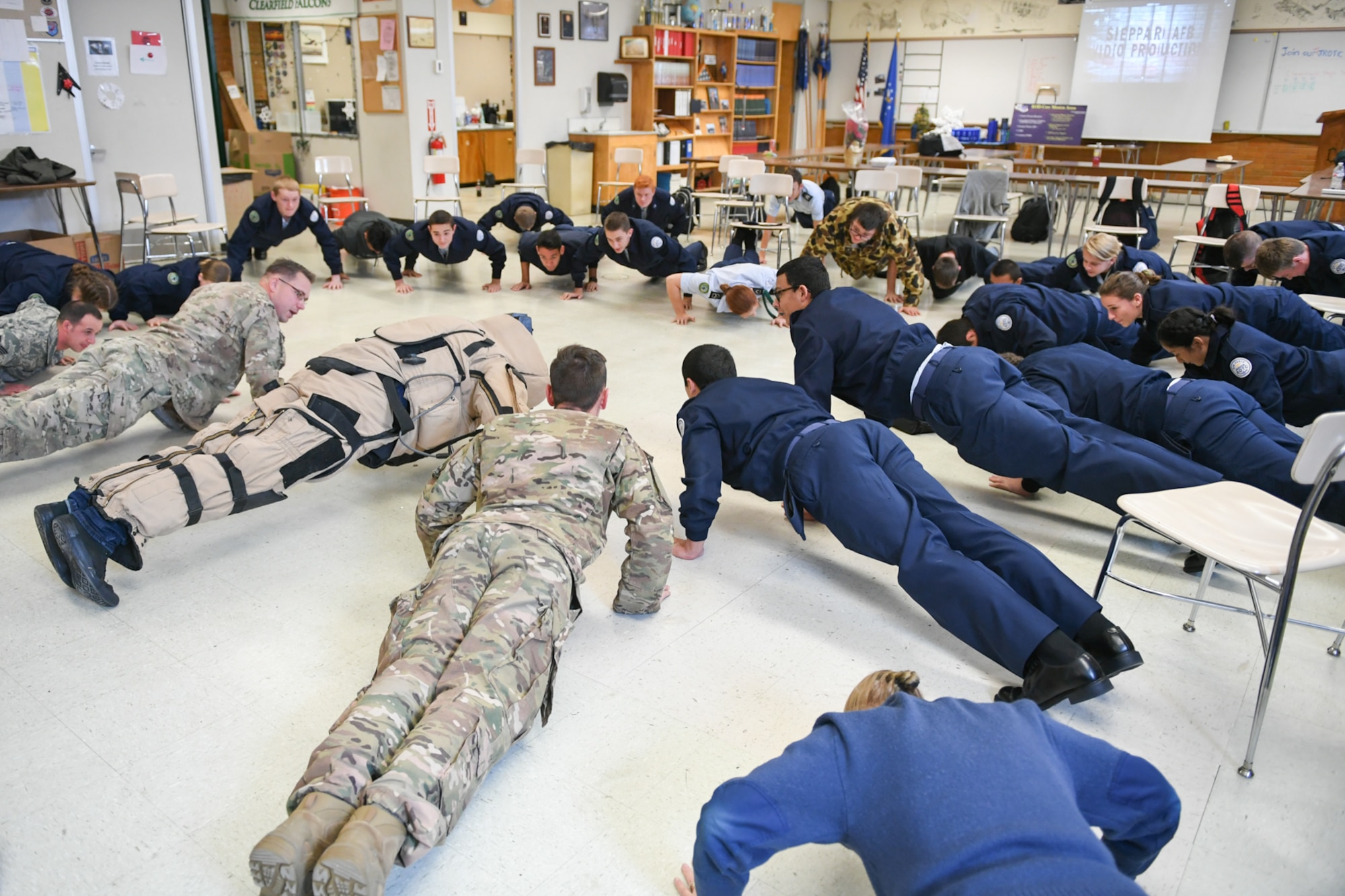 Airmen from Hill’s explosive ordnance disposal team and students from Clearfield High School’s Junior ROTC class perform push-ups as part of an Air Force Reserve recruiting event Dec. 12.