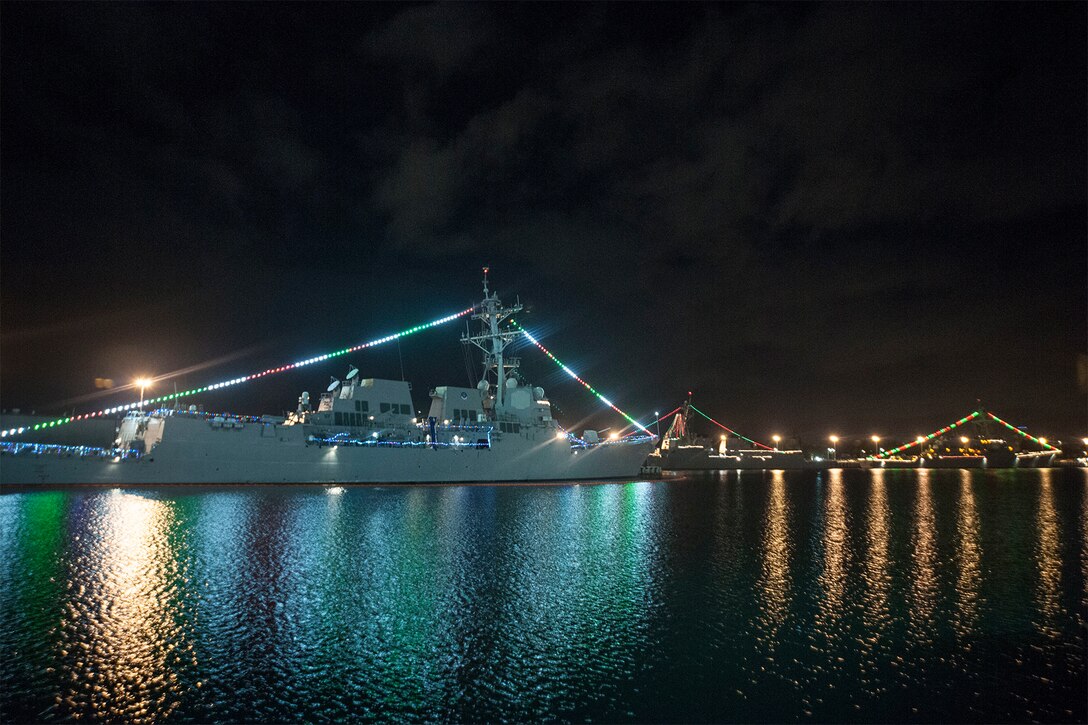 A Navy ship is decorated with Christmas lights.