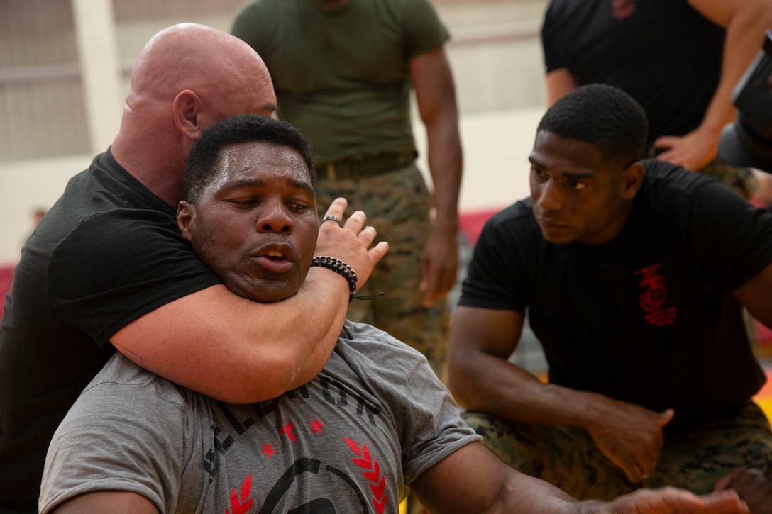 Martial Arts Instructor Jay Glazer and former professional football player and mixed martial artist Herschel Walker demonstrate mixed martial arts (MMA) at the Special MMA Clinic held aboard Marine Corps Base Hawaii, Dec. 11, 2018. MMA figure heads hosted by the United Service Organization spoke about and demonstrated their competative combat sport experience to Marines aboard the base, relating the skill set to the Marine Corps Martial Arts Program and the everpresent Marine Corps combat mindset. (U.S. Marine Corps Photo by Sgt. Alex Kouns)