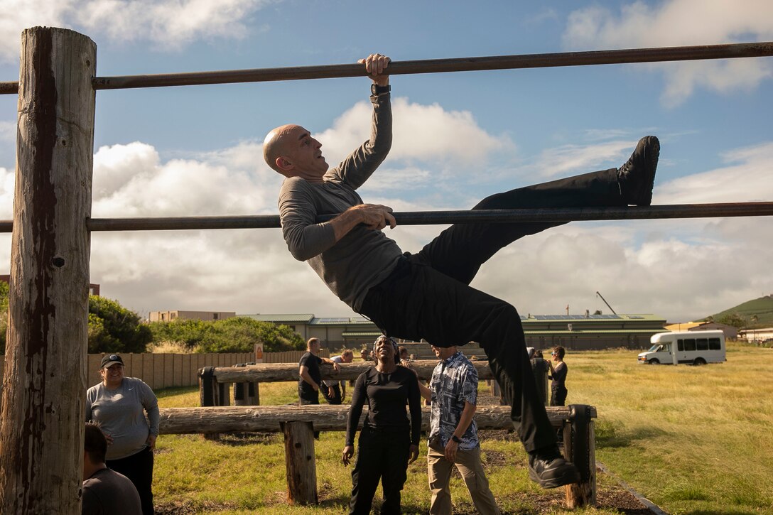 Sean McPherson, a program analyst chief with Naval Operations Air Warfare Division, traverses over a bar during the obstacle course at Landing Zone Boondocker, Marine Corps Base Hawaii, Dec. 11, 2018. The program provides leadership development opportunities and addresses key competencies for high potential employees at the GS-13 and 14 levels or equivalent whose career plans include moving into upper management positions. (U.S. Marine photo by Sgt. Zachary Orr)