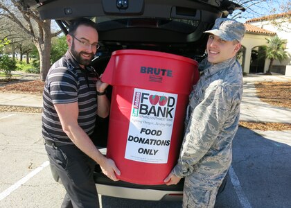 Jason Wheeler, 359th Medical Operations Squadron physical therapist, left, and 2nd Lt. Michael Ehlen, 12th Training Squadron student pilot, place a container of nonperishable food items into a vehicle for eventual transport to the San Antonio Food Bank Dec. 10, 2018, at Joint Base San Antonio-Randolph. The 359th MDOS Physical Therapy Flight is leading two drives during the holiday season: One of them will benefit the San Antonio Food Bank, while the other will provide relief to the victims of Hurricane Michael.