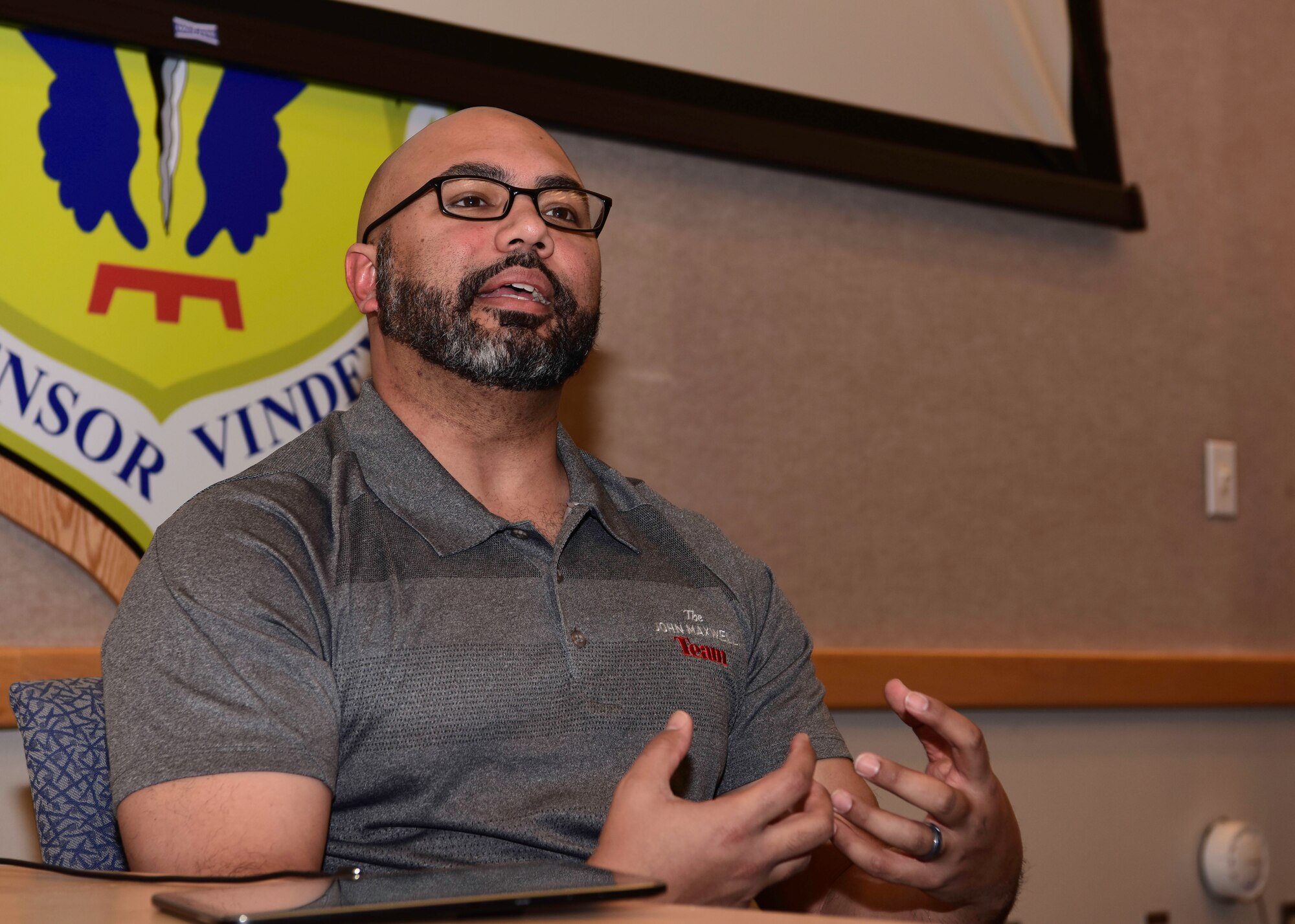 Retired Senior Master Sgt. John De La Rosa, an executive director with the John Maxwell Team speaks in front of a group of Airmen about leadership during the John C. Maxwell Leadership Seminar.