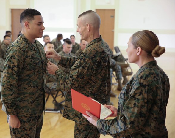 U.S. Marine Corps Brig. Gen. Stephen M. Neary, commanding general of 2nd Marine Expeditionary Brigade, presents a Navy and Marine Corps Achievement Medal to Cpl. Elijah Ballantyne, a 2nd MEB supply administrator, at Camp Lejeune, N.C., Dec. 11, 2018. Ballantyne received the award for his exemplary performance while supporting the unit during Exercise Trident Juncture 18 in Norway. The award is earned by exemplifying superior performance outside one’s designated military occupational specialty. (U.S. Marine Corps photo by Cpl. Patrick Osino)