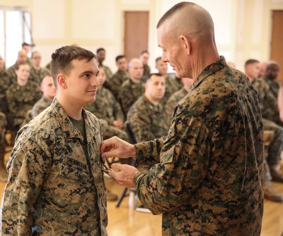 U.S. Marine Corps Brig. Gen. Stephen M. Neary, commanding general of 2nd Marine Expeditionary Brigade, presents a Navy and Marine Corps Achievement Medal to Cpl. Cody Sherington, a 2nd MEB data systems administrator, at Camp Lejeune, N.C., Dec. 11, 2018. Sherington received the award for his exemplary performance while supporting the unit during Exercise Trident Juncture 18 in Norway. The award is earned by exemplifying superior performance outside one’s designated military occupational specialty. (U.S. Marine Corps photo by Cpl. Patrick Osino)