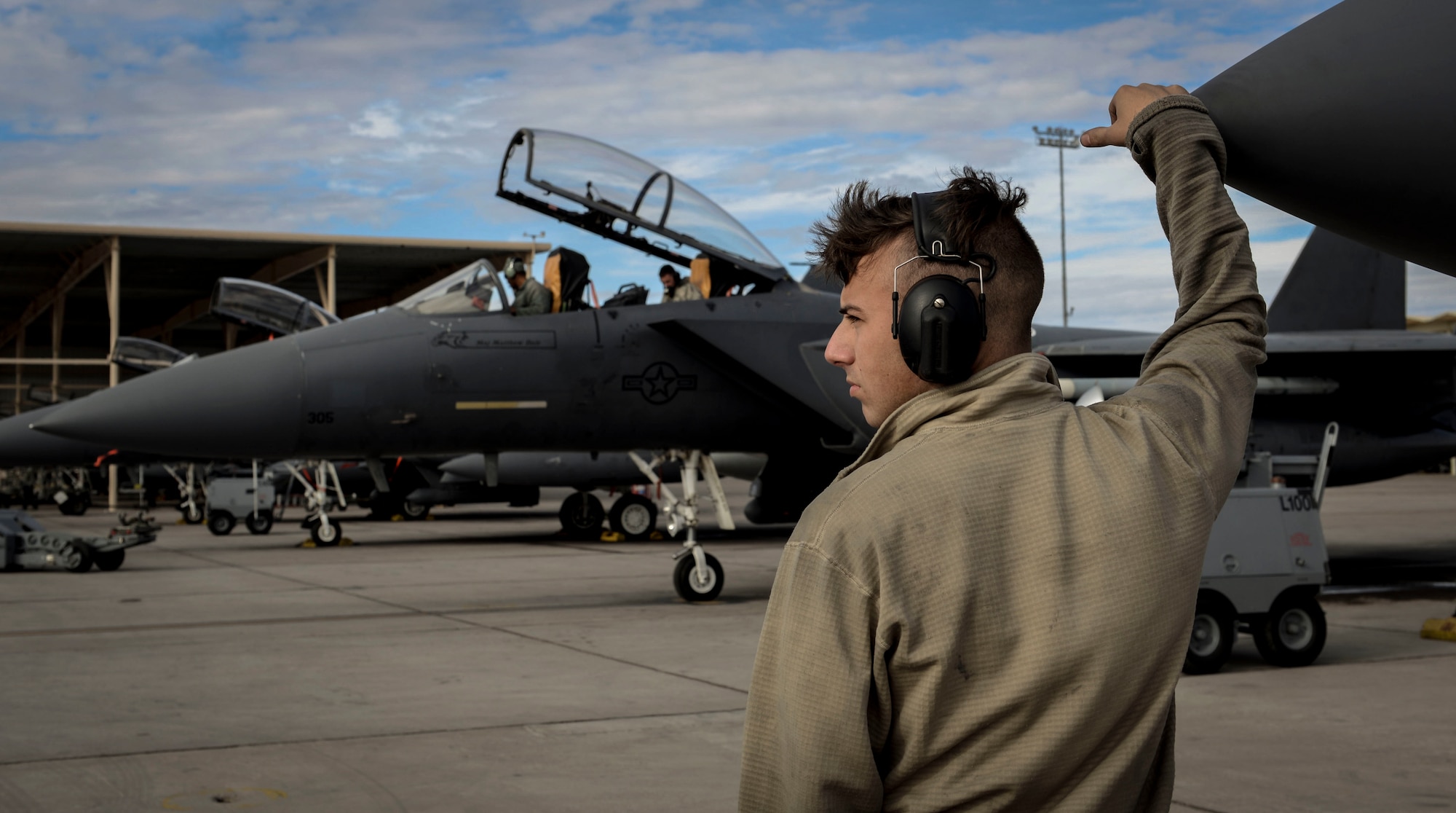 Airman 1st Class Clayton Ackerman, 757th Aircraft Maintenance Squadron (AMXS) Strike Aircraft Maintenance Unit F-15E Strike Eagle fighter jet maintainer, looks on as an F-15E prepares to launch Dec. 4, 2018 at Nellis Air Force Base, Nevada. The 757th AMXS participated alongside their pilots during the Weapons School Integration. (U.S. Air Force photo by Airman 1st Class Bailee A. Darbasie)