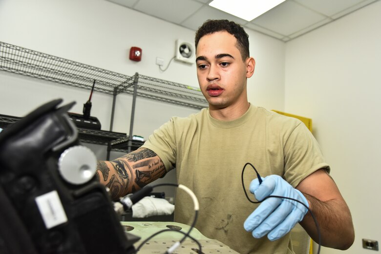 U.S. Air Force Airman Isaiah Edwards, 380th Expeditionary Maintenance Squadron non-destructive inspection technician, operates an ultrasonic transducer machine to find cracks in metal aircraft parts at Al Dhafra Air Base, United Arab Emirates, Dec. 7, 2018. The NDI shop uses certain techniques including fluorescent penetrant inspections and special oil analyses. These are some of the numerous methods used to repair, diagnose or prevent damage to the aircraft, its oil, and the parts. (U.S. Air Force photo by Senior Airman Mya M. Crosby)