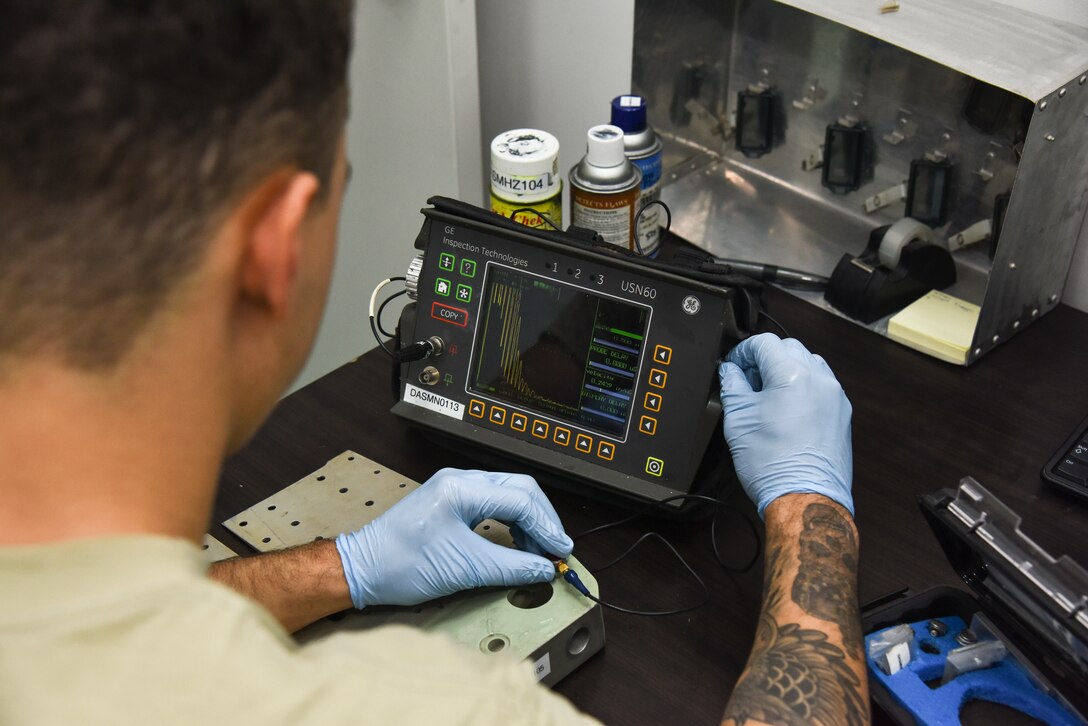 U.S. Air Force Airman Isaiah Edwards, 380th Expeditionary Maintenance Squadron non-destructive inspection technician, operates an ultrasonic transducer machine to find cracks in metal aircraft parts at Al Dhafra Air Base, United Arab Emirates, Dec. 7, 2018. The NDI shop uses certain techniques including fluorescent penetrant inspections and special oil analyses. These are some of the numerous methods used to repair, diagnose or prevent damage to the aircraft, its oil, and the parts. (U.S. Air Force photo by Senior Airman Mya M. Crosby)