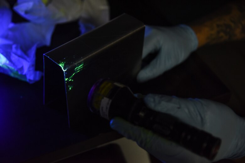 U.S. Air Force Airman Isaiah Edwards, 380th Expeditionary Maintenance Squadron non-destructive inspection technician, identifies cracks in an aircraft part at Al Dhafra Air Base, United Arab Emirates, Dec. 7, 2018. NDI combines science with technology to evaluate the integrity of structures, metals, system components, and fluids without causing any damage, or impairing future usefulness to any parts. (U.S. Air Force photo by Senior Airman Mya M. Crosby)