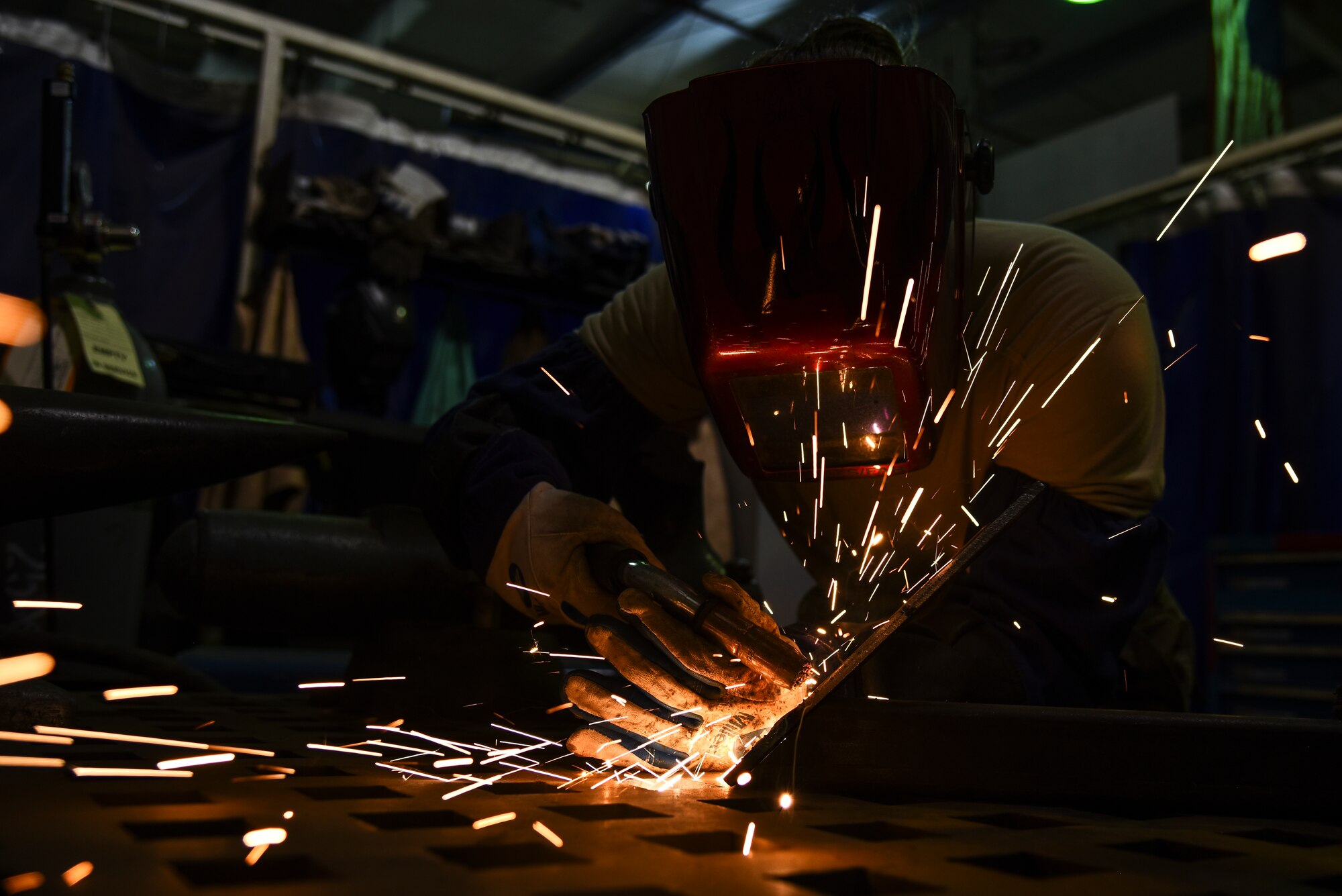 U.S. Air Force Senior Airman Courtnee Grafton, 380th Expeditionary Maintenance Squadron metal technician, welds a piece of metal at Al Dhafra Air Base, United Arab Emirates, Dec. 9, 2018. The 380th EMXS fabrication flight is in charge of identifying and repairing aircraft structural damage.  (U.S. Air Force photo by Senior Airman Mya M. Crosby)