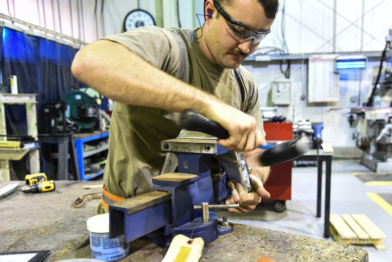 U.S. Air Force Airman 1st Class David Stackhouse, 380th Expeditionary Maintenance Squadron aircraft structural repair technician, repairs an aircraft part at Al Dhafra Air Base, United Arab Emirates, Dec. 9, 2018. The 380th EMXS fabrication flight is in charge of identifying and repairing aircraft structural damage. (U.S. Air Force photo by Senior Airman Mya M. Crosby)