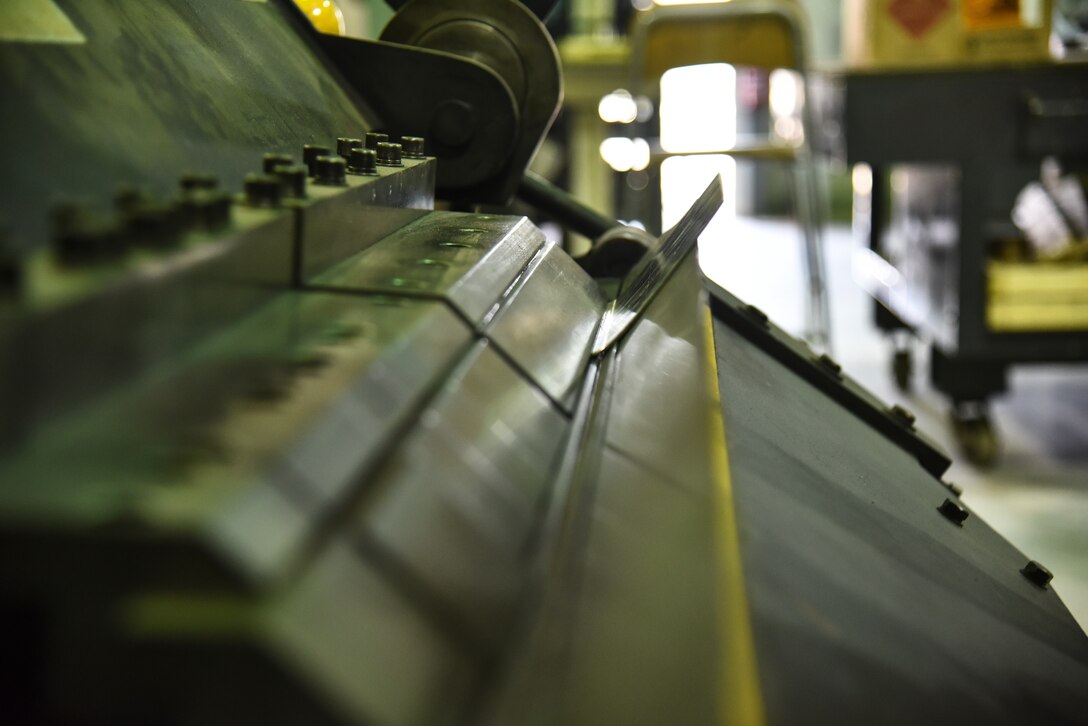 A box and pan break bends a piece of metal at Al Dhafra Air Base, United Arab Emirates, Dec. 9, 2018. The sheet metals shop is in charge of receiving deficient parts from all over the installation and fixing them, making them a very cost-efficient method, rather than purchasing a new part. (U.S. Air Force photo by Senior Airman Mya M. Crosby)