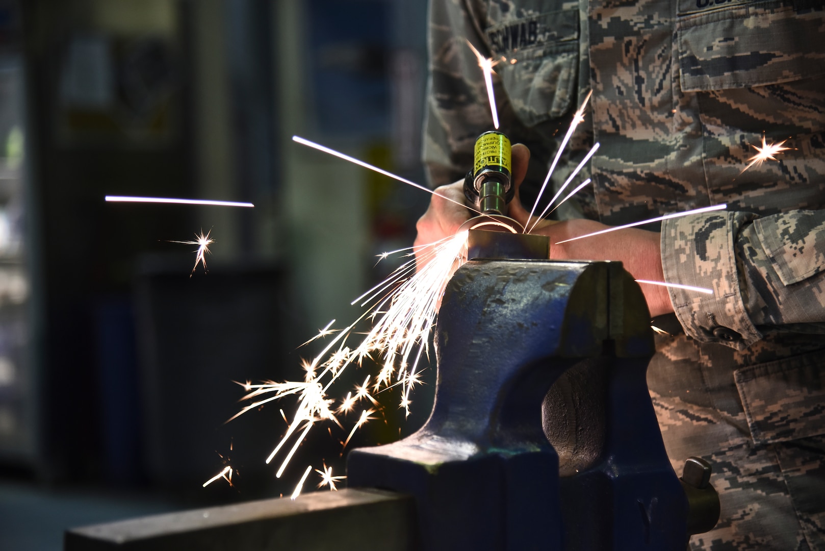 U.S. Air Force Senior Airman Steven Schwab, 380th Expeditionary Maintenance Squadron aircraft structural repair technician, cleaning up the edge of a titanium metal piece at Al Dhafra Air Base, United Arab Emirates, Dec. 9, 2018. The fabrication flight, also known as “fab flight” or the “American chopper of aircraft maintenance” is comprised of Sheet Metals, Non-Destructive Inspection and Aircraft Structural Repair technicians. (U.S. Air Force photo by Senior Airman Mya M. Crosby)