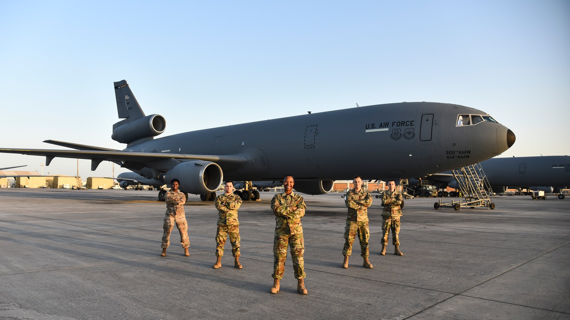 The 380th Expeditionary Maintenance Group maintenance operations center poses in front of KC-10 Extender at Al Dhafra Air Base, United Arab Emirates, Dec. 9, 2018. The 380th EMXG MOC support approximately 520 personnel and 24 aircraft including an additional influx of transient aircraft. (U.S. Air Force photo by Senior Airman Mya M. Crosby)
