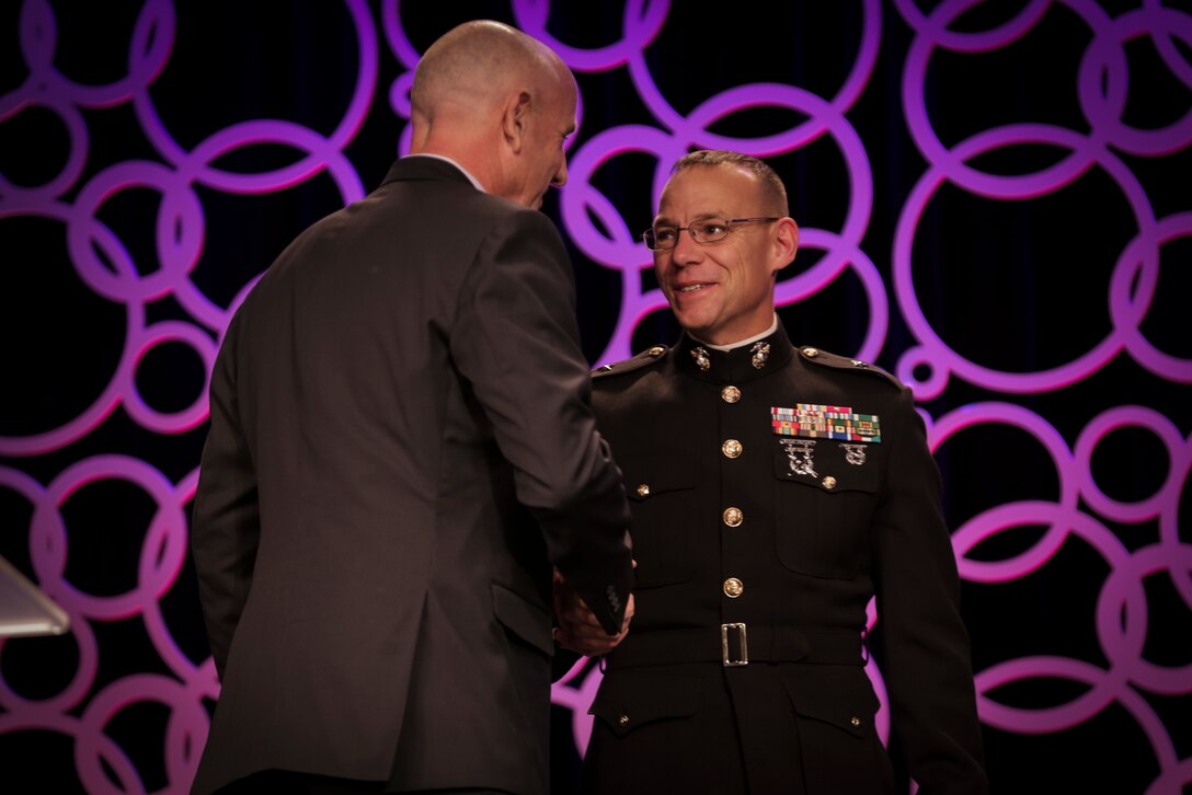 Brig. Gen. Ryan Heritage, the commanding general of Western Recruiting Region and Marine Corps Recruit Depot San Diego, presents Alan Knipe, Long Beach State University men's volleyball head coach, the 2018 United States Marine Corps American Volleyball Coach's Association NCAA Division 1-2 Men's National Coach of the Year Award during the AVCA 2018 National Convention in Minneapolis, Minnesota, December 13, 2018. The AVCA Convention gives the Marine Corps an opportunity to connect with more than 2,800 volleyball coaches who are members of the AVCA. (U.S. Marine Corps photo by LCpl Haley Gawronski)