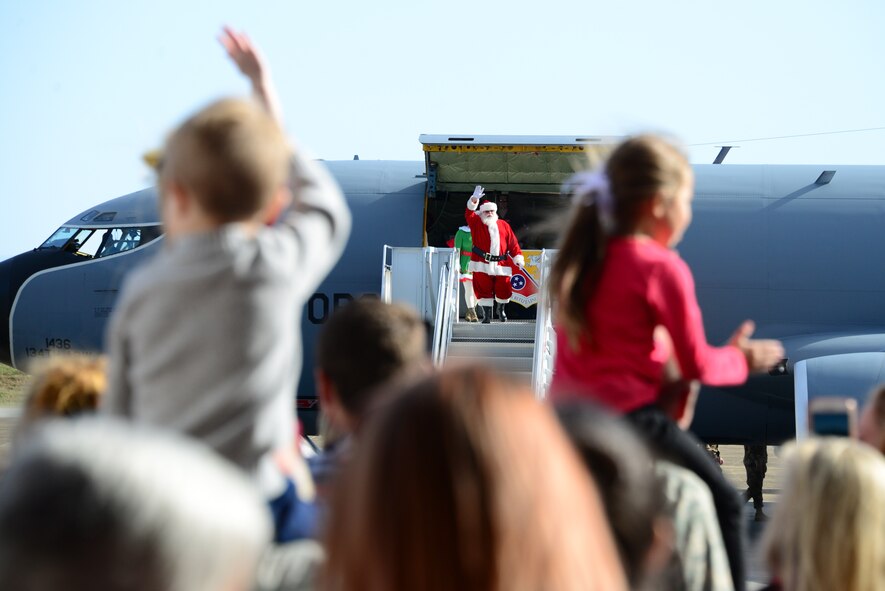 Santa walks out of a KC-135, waving
